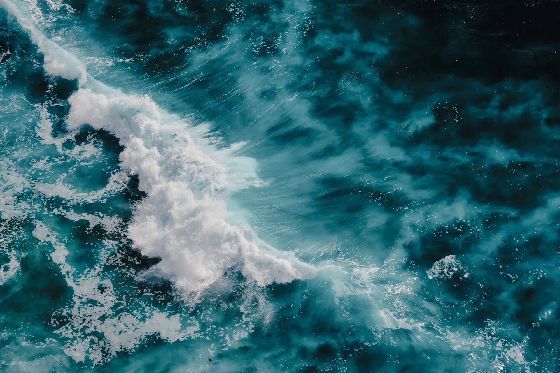 Turquoise ocean waves crashing with white foam